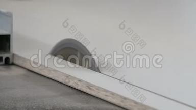 刨花板锯床.. 圆锯切断了一部分白色叠层木片。 特写镜头。 真正的木头声音